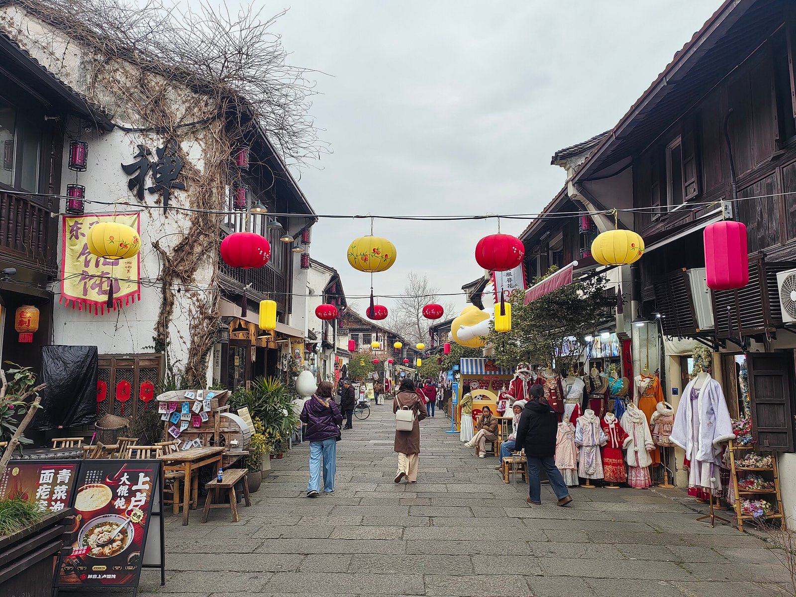 The canal-side historic lane of Xiaohe Zhijie in Hangzhou with hanging lanterns and costume shops, where The Best Thing's coffee-shop scenes were shot