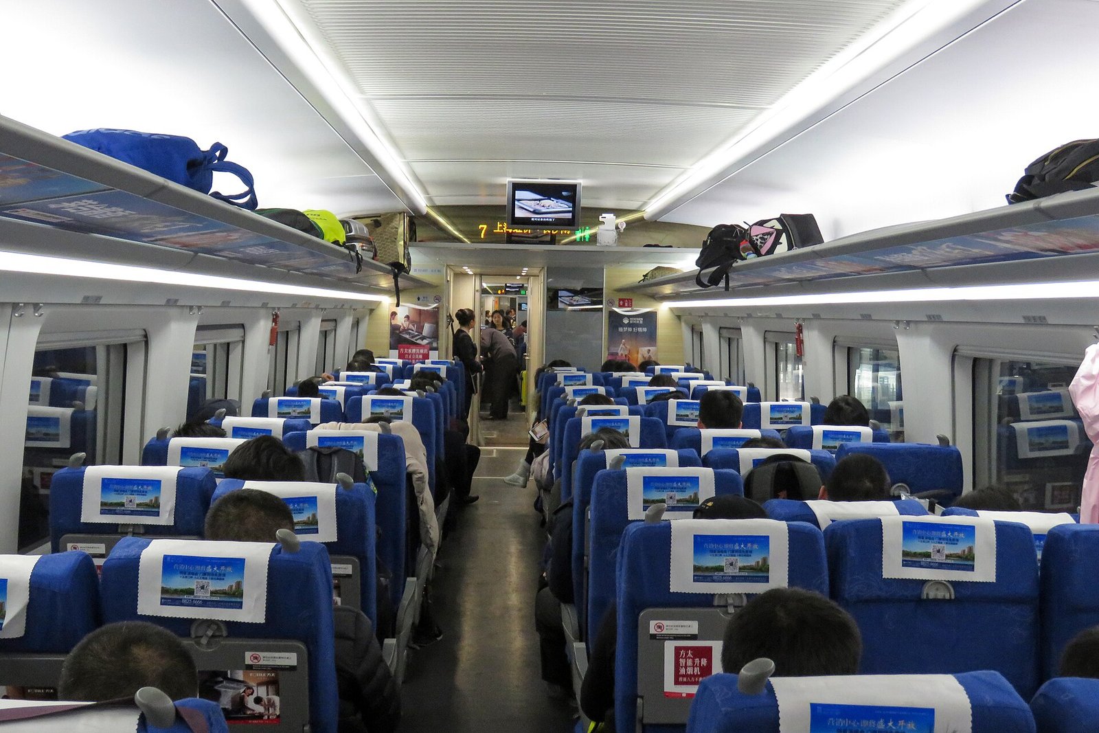 The interior of a China Railway high-speed train carriage with blue seats, where most of a multi-city C-drama itinerary is spent