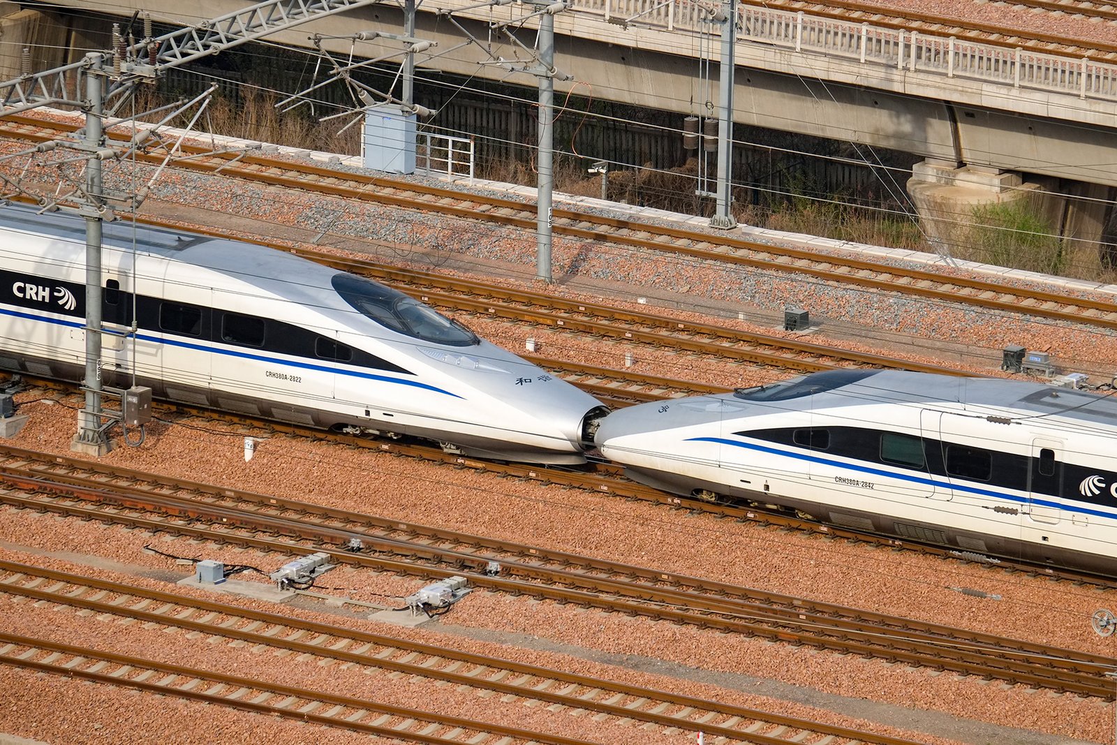 Two CRH380A high-speed train sets standing side by side at a Chinese railway station