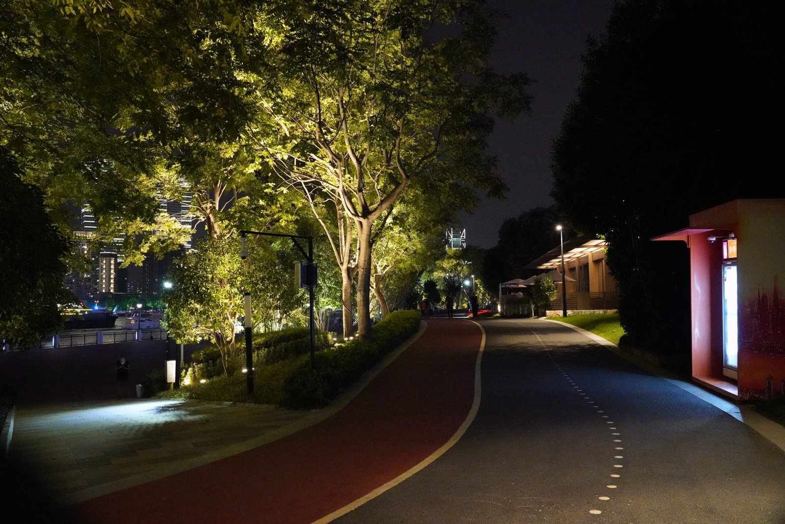 The riverside green belt and public walkway in Yangpu District, Shanghai, lit at night, with jogging and cycling lanes