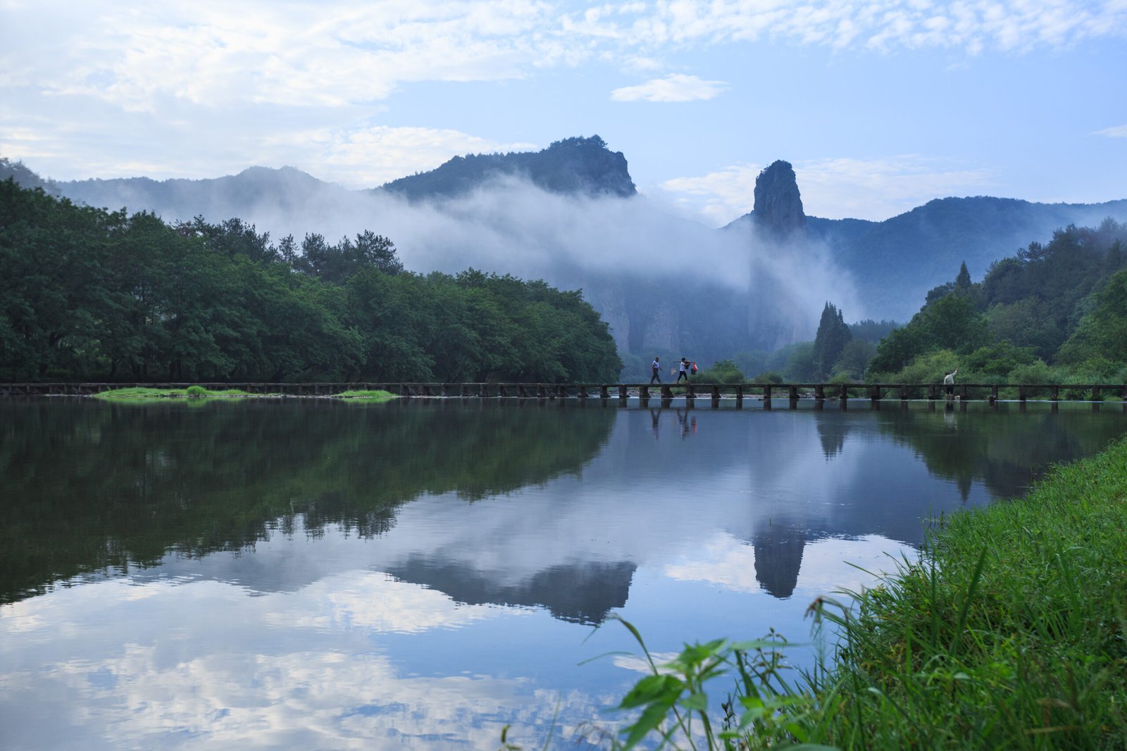 Dinghu Peak rising out of morning mist behind the stone beam bridge at Xiandu, Jinyun, Zhejiang