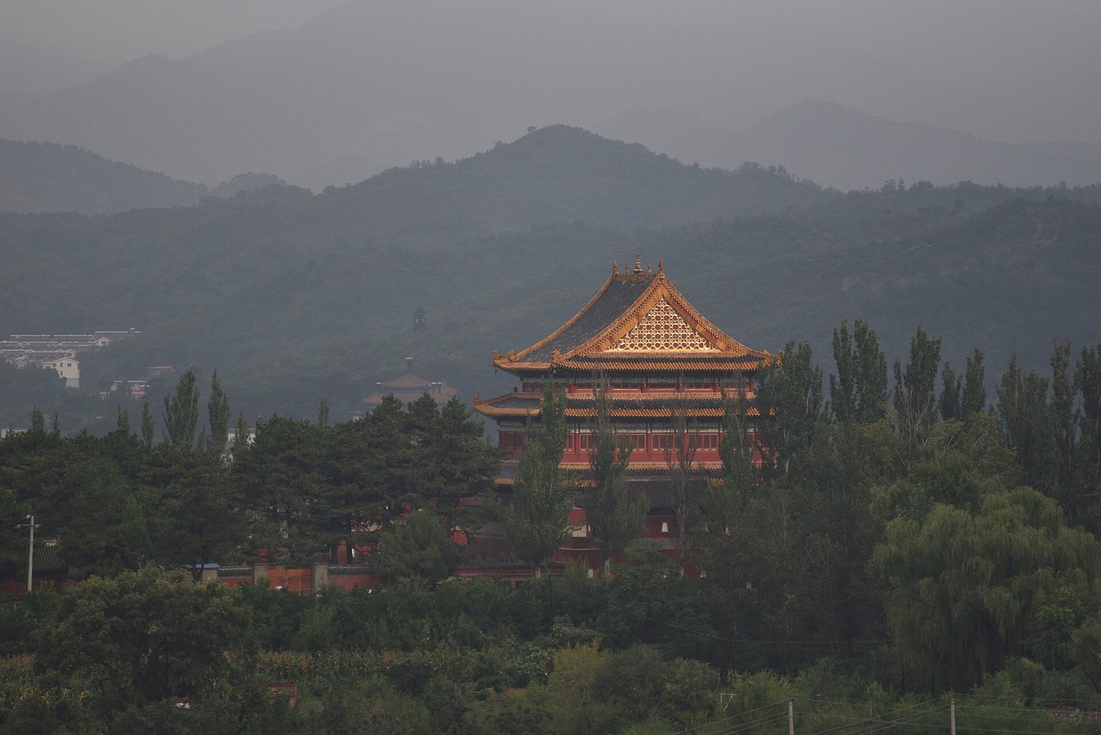 The Pudu Hall of Anyuan Temple at Chengde emerging from morning mist, with hills behind