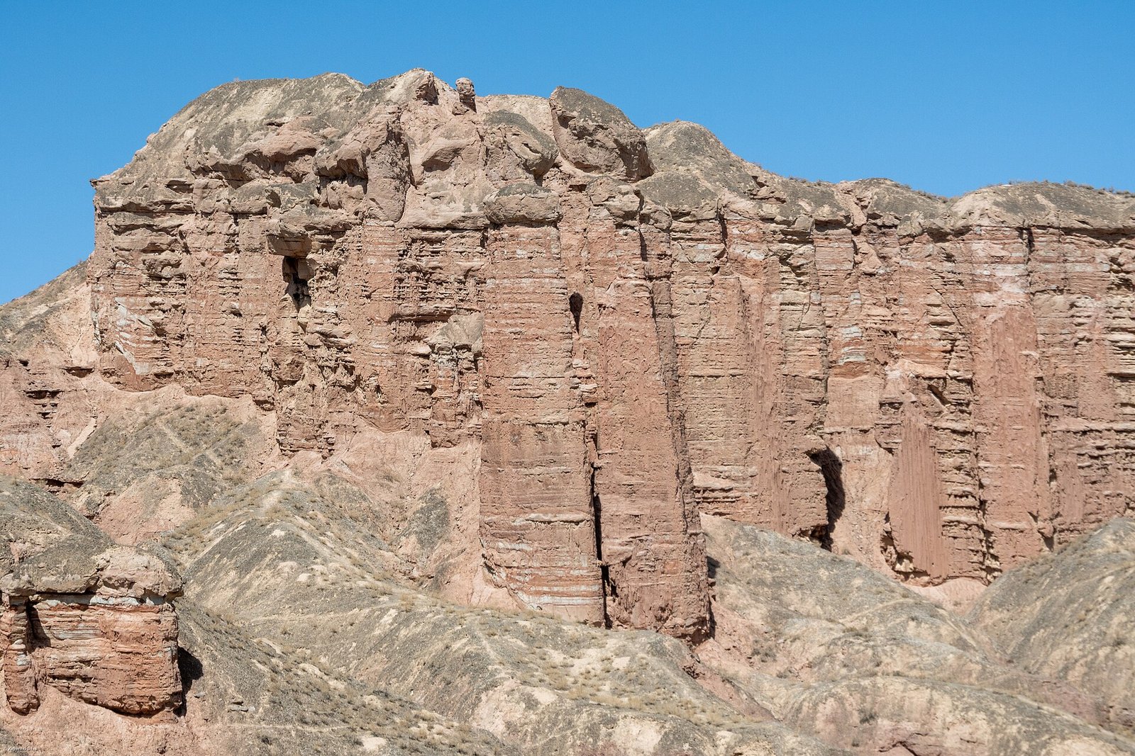 Tall eroded rock columns and walls at Binggou Danxia in Sunan County, forming a palatial cliff face