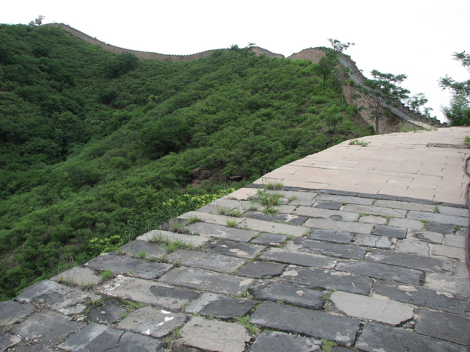 The stone boundary wall of the Chengde Mountain Resort climbing a wooded ridge