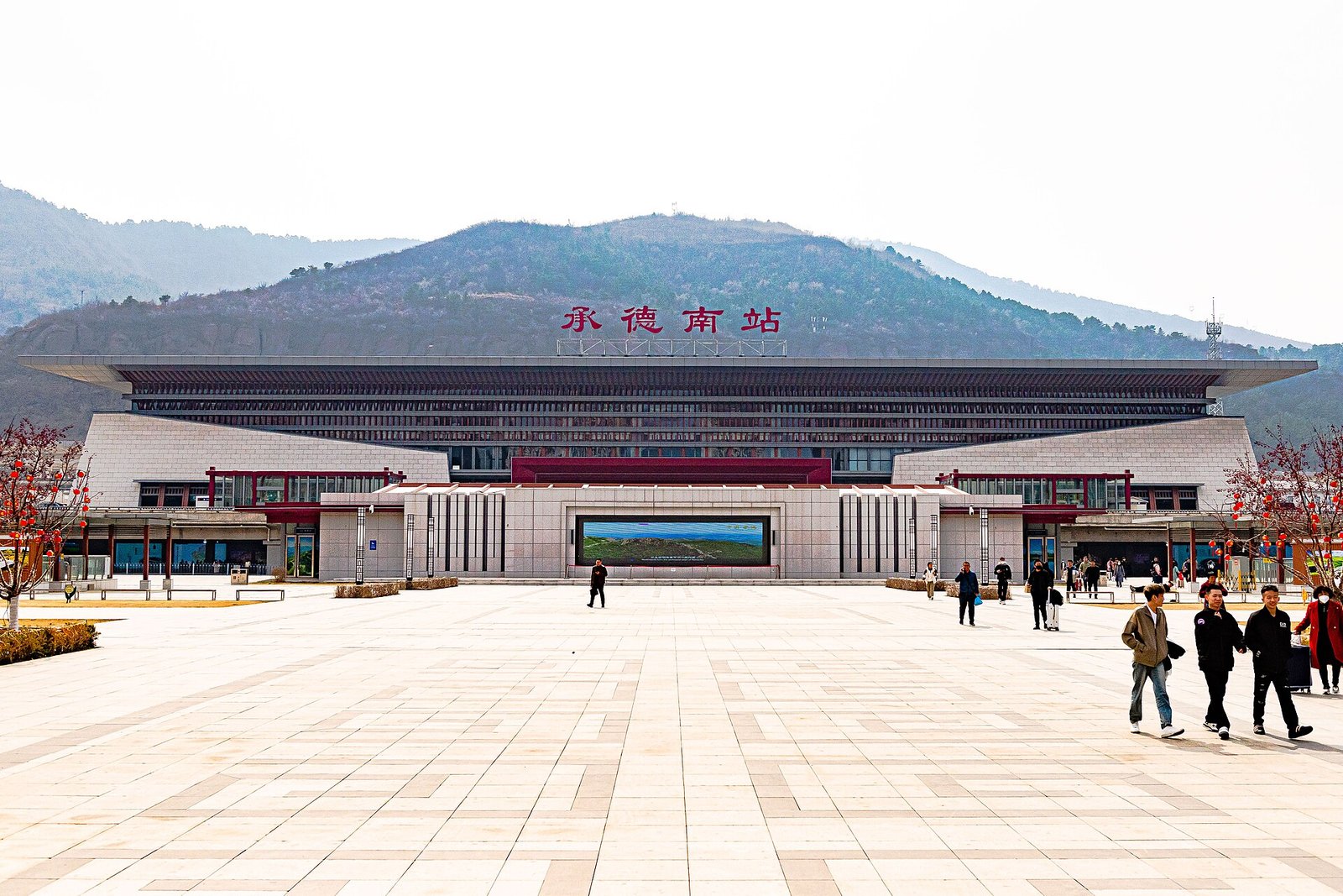 The wide facade and forecourt of Chengde South railway station under a clear sky