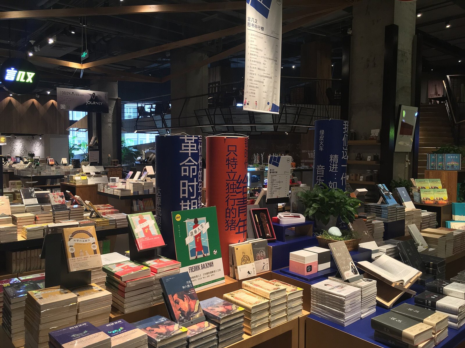 Book tables and shelves inside a Chengdu bookshop, with promotional banners overhead