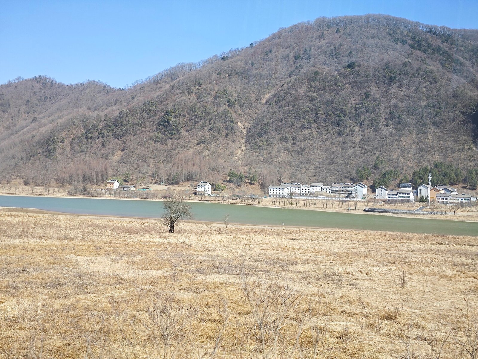 The first of the nine lakes at Dajiuhu in Shennongjia, with wetland grass and mountains along the rim