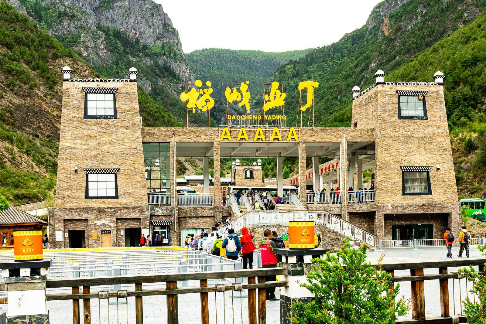The entrance gate of the Daocheng Yading scenic area with its name in Chinese characters above the road