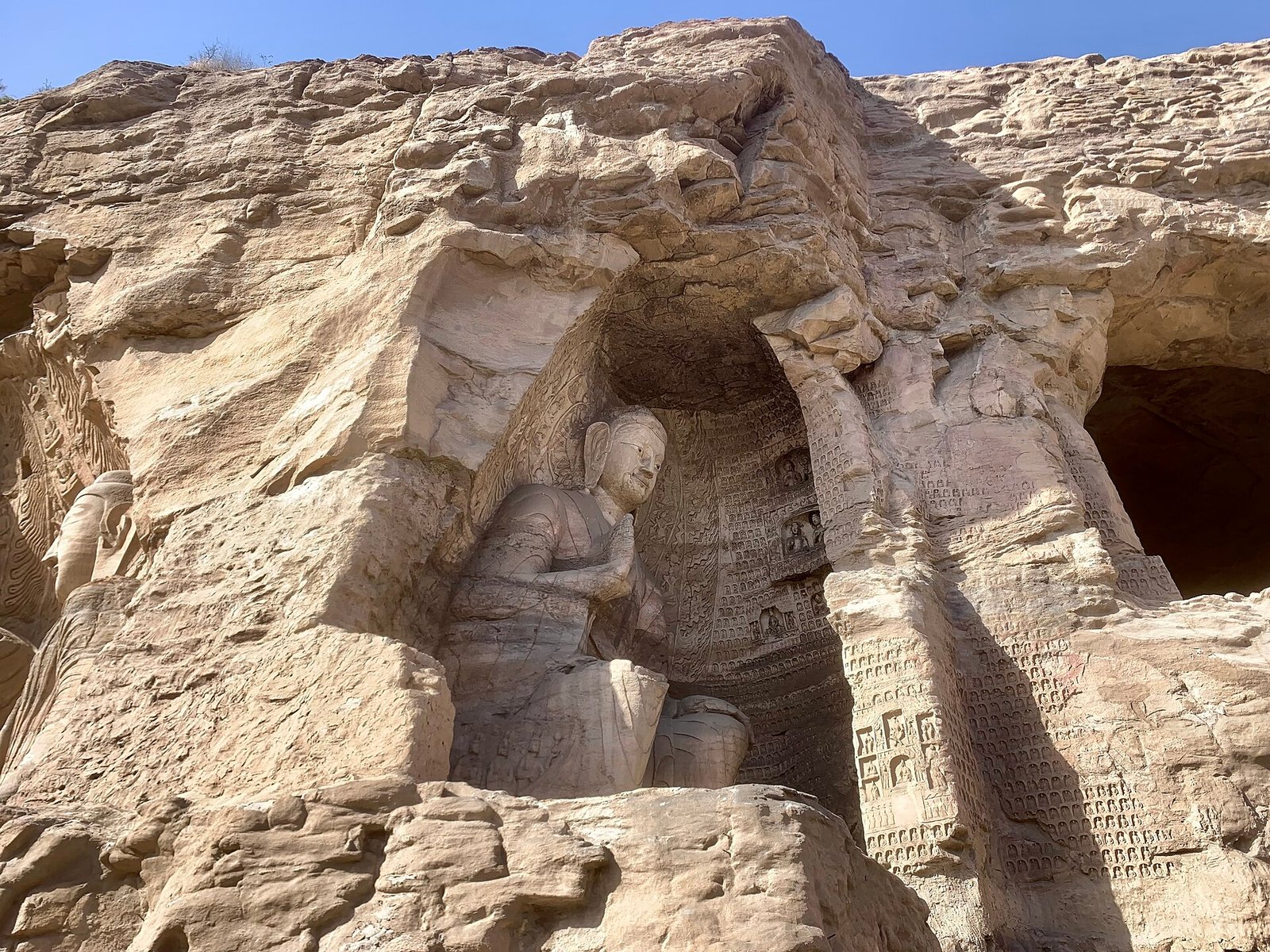 The seated Buddha of Cave 20 at the Yungang Grottoes, with two attendant figures