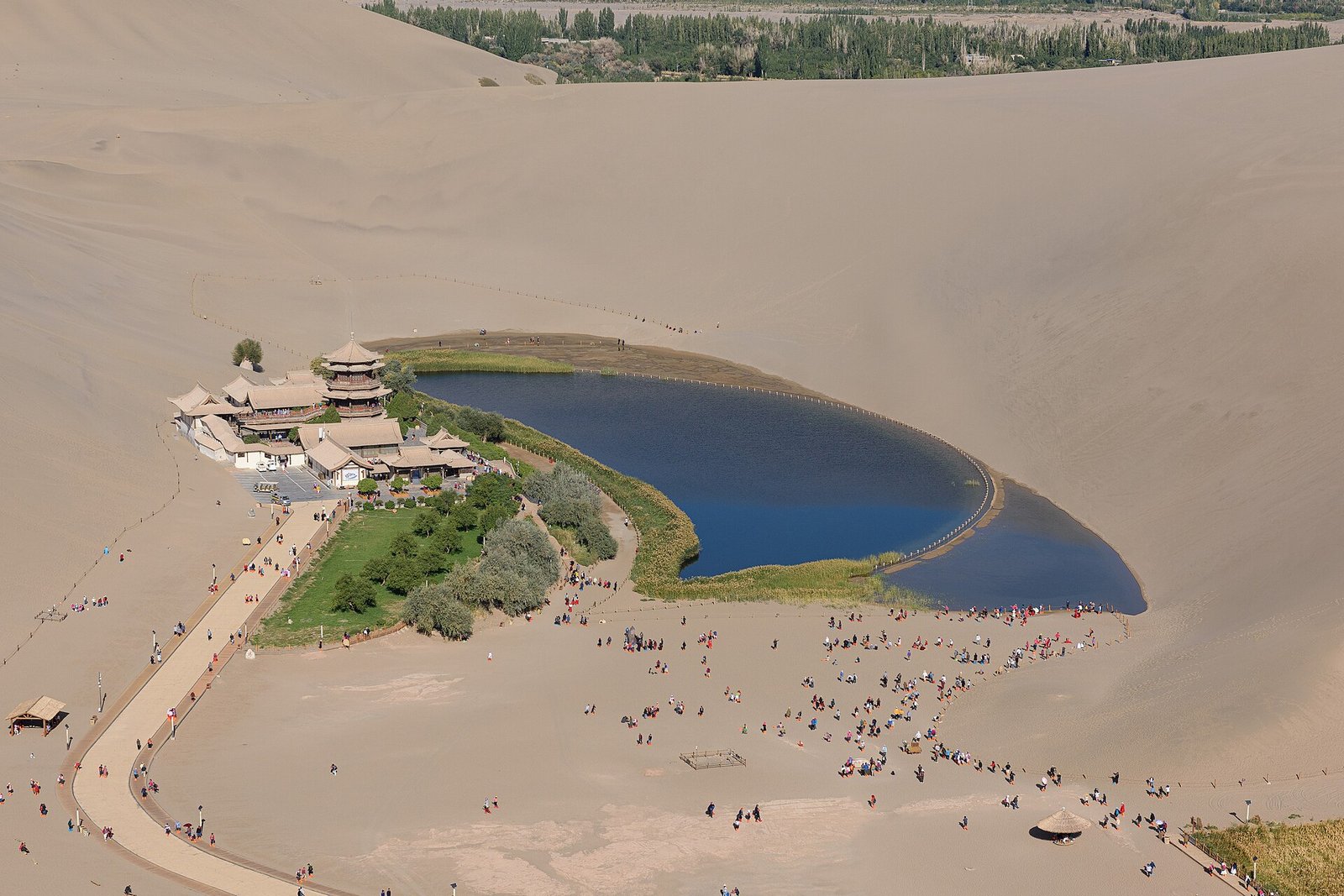 The Singing Sand Dunes wrapping around the crescent-shaped Crescent Lake at Dunhuang, Gansu