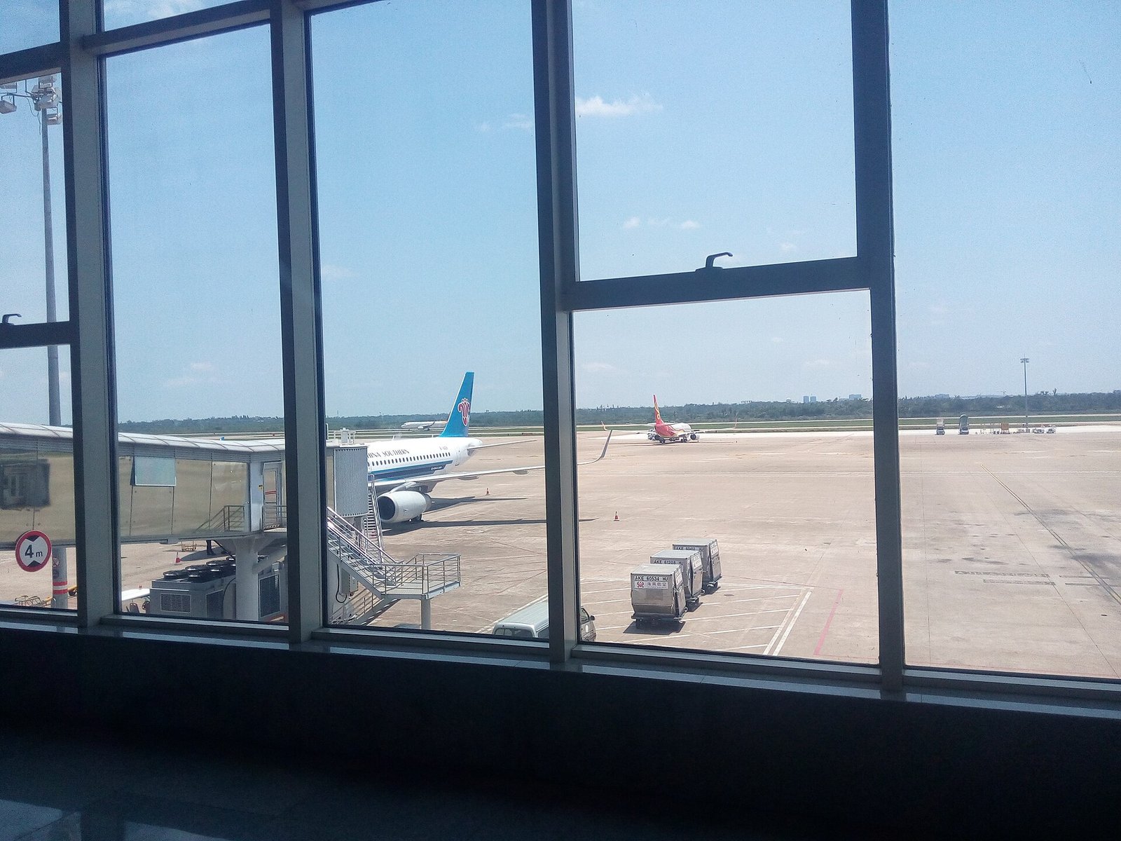 Aircraft on the apron at Haikou Meilan International Airport seen through the terminal windows