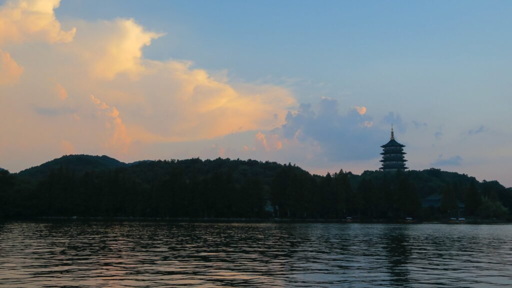 The Leifeng Pagoda silhouetted across West Lake in Hangzhou at dusk