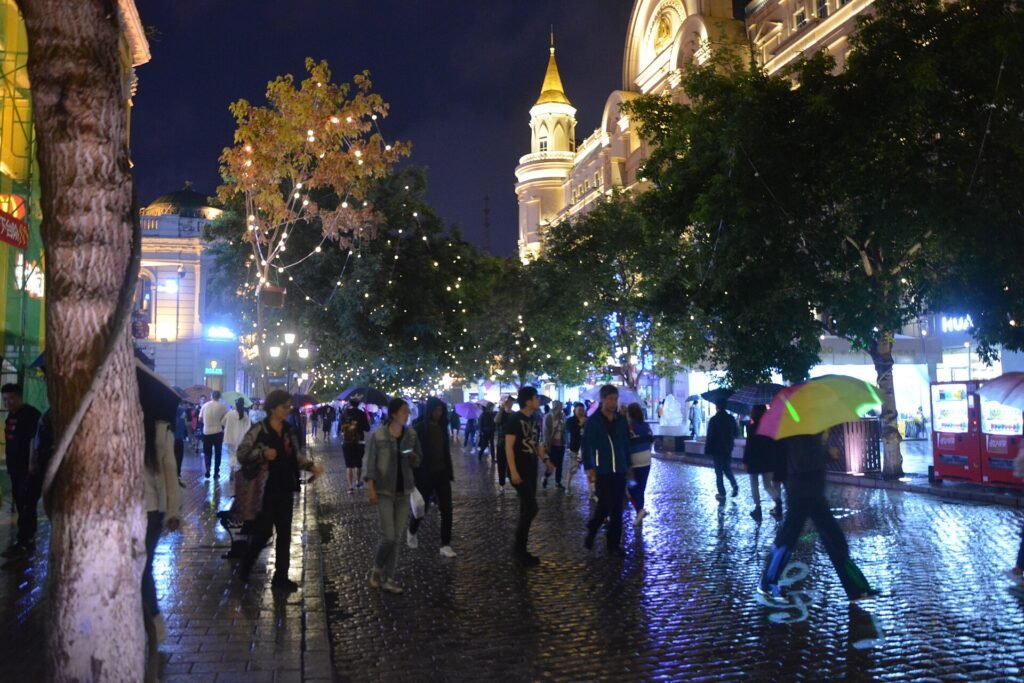Central Street in Harbin lit up at night, with European-style facades and crowds of pedestrians