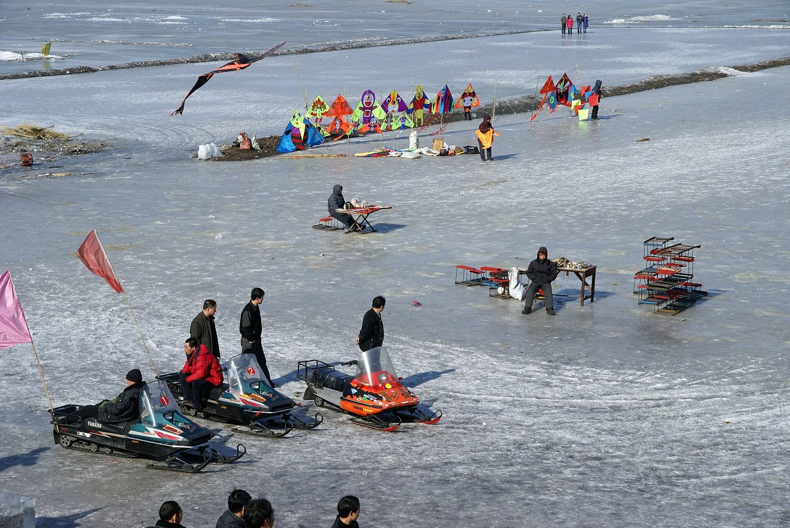 People walking and sledging on the frozen Songhua River in Harbin in winter