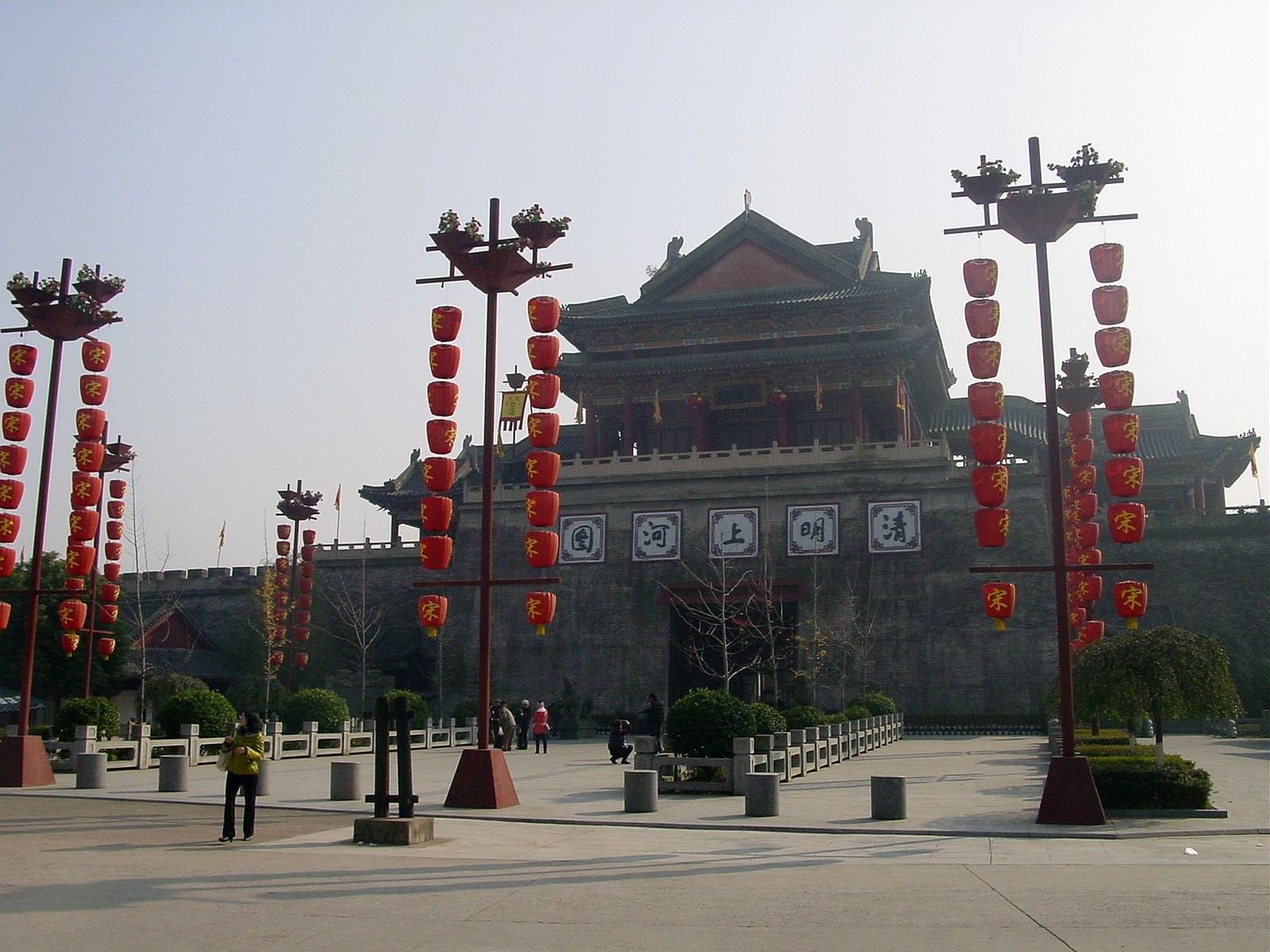 The gate of the Along the River During the Qingming Festival area at Hengdian World Studios, with its name plaque and rows of red lanterns