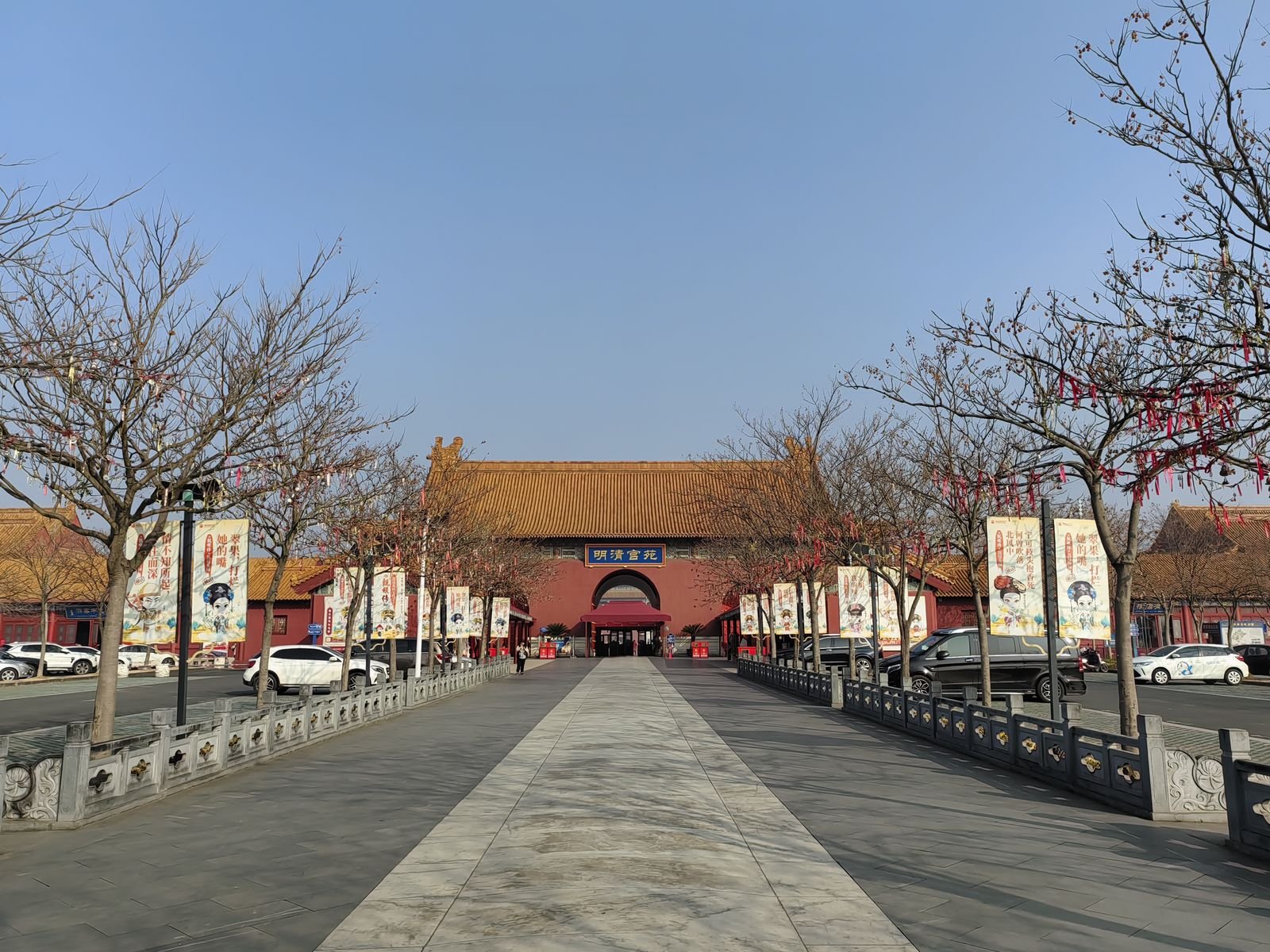 The main gate of Ming Qing Palace at Hengdian World Studios, a red wall and yellow glazed roof with the name plaque above the entrance