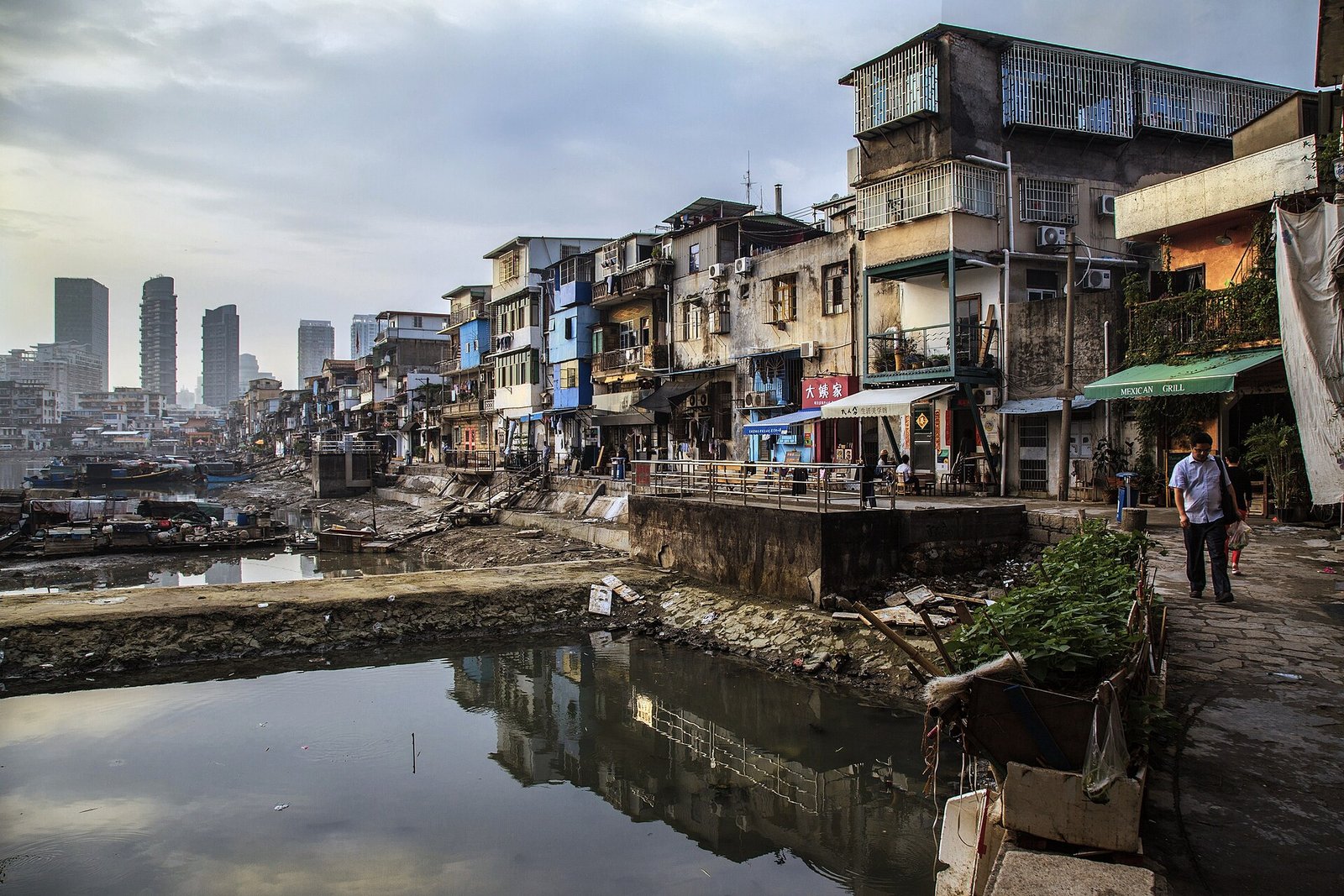 Fishing boats moored in the old Shapowei typhoon shelter in Xiamen, with the city's high-rise towers rising behind