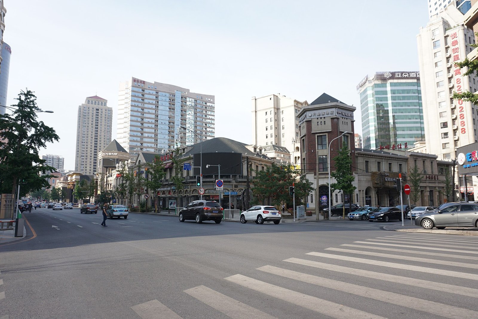 The ring of European-style buildings around Zhongshan Square in Dalian seen from street level across the road