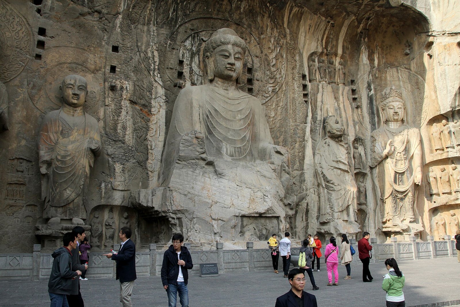 The Fengxian Temple group at the Longmen Grottoes, with visitors at the foot of the great Buddha