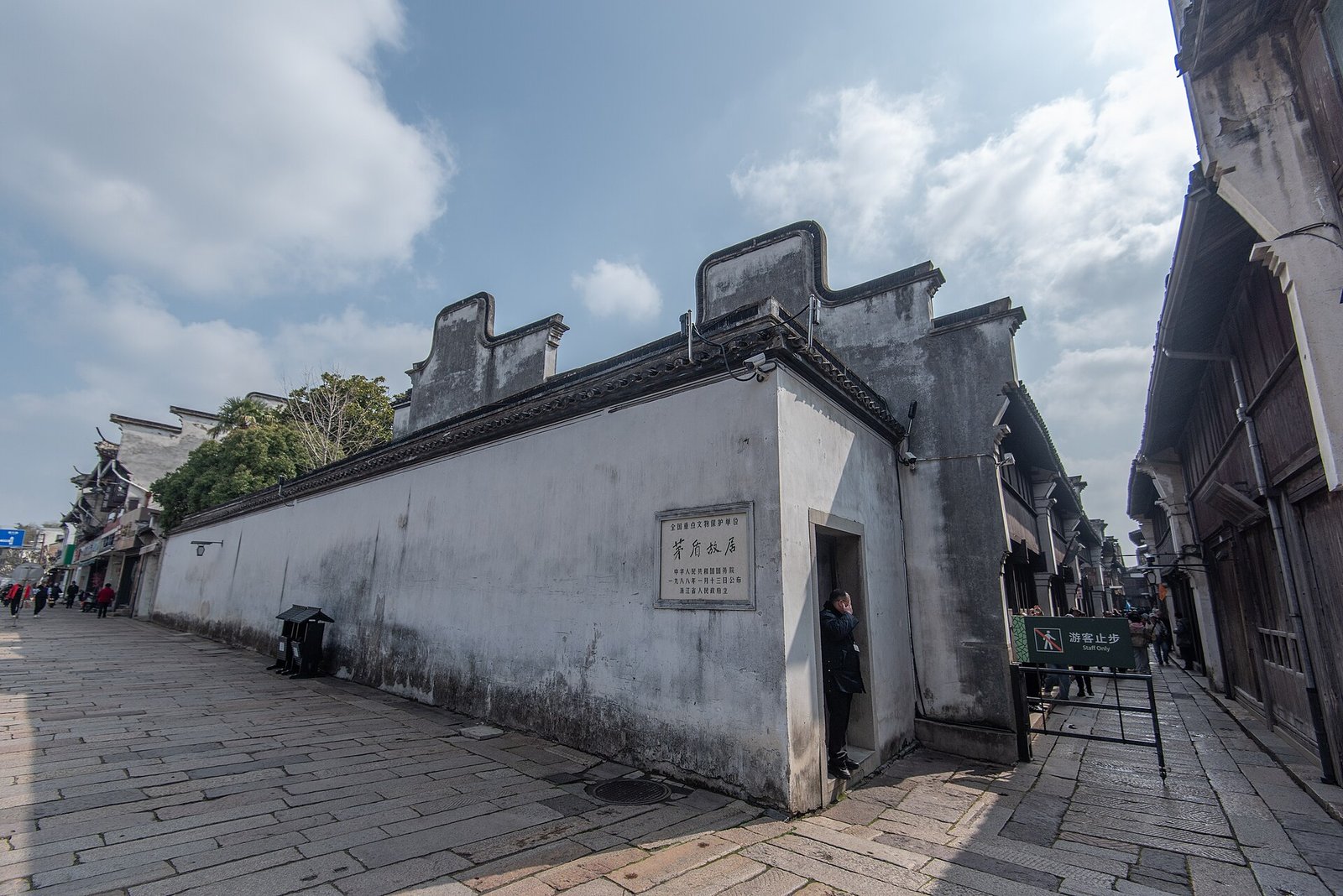 The dark timber gateway of the Mao Dun former residence in Wuzhen Dongzha, with a stone plaque above the door