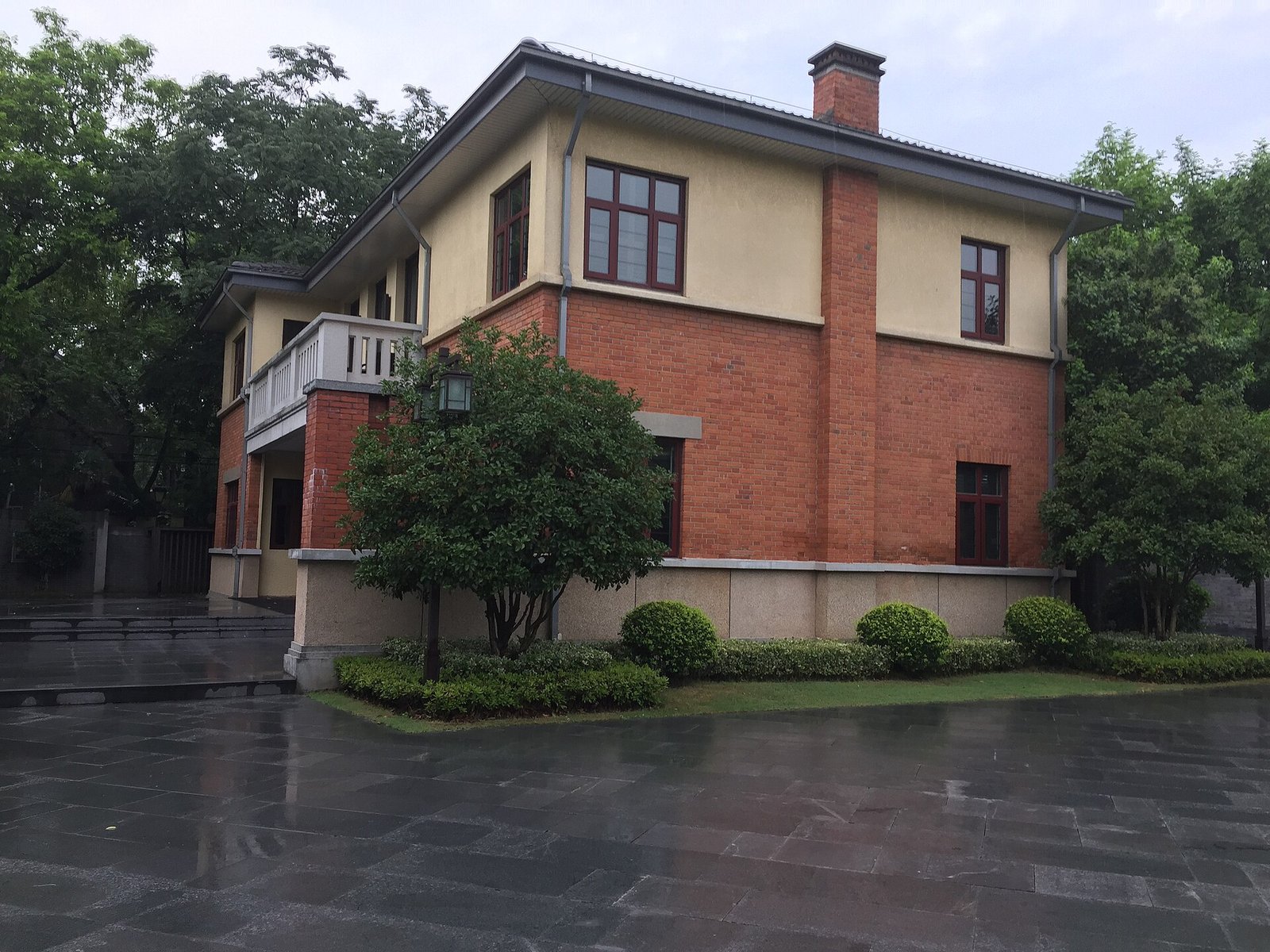 A quiet tree-lined avenue of low 1930s brick houses with high walls in a Chinese city