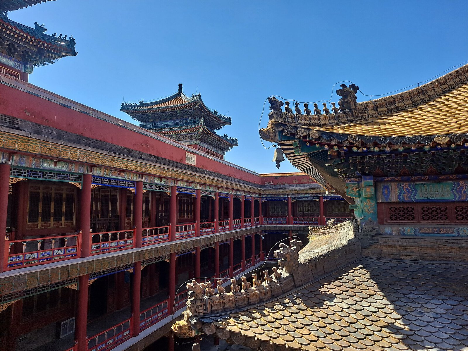 The tall red terrace of Putuo Zongcheng Temple at Chengde with golden roofs behind it