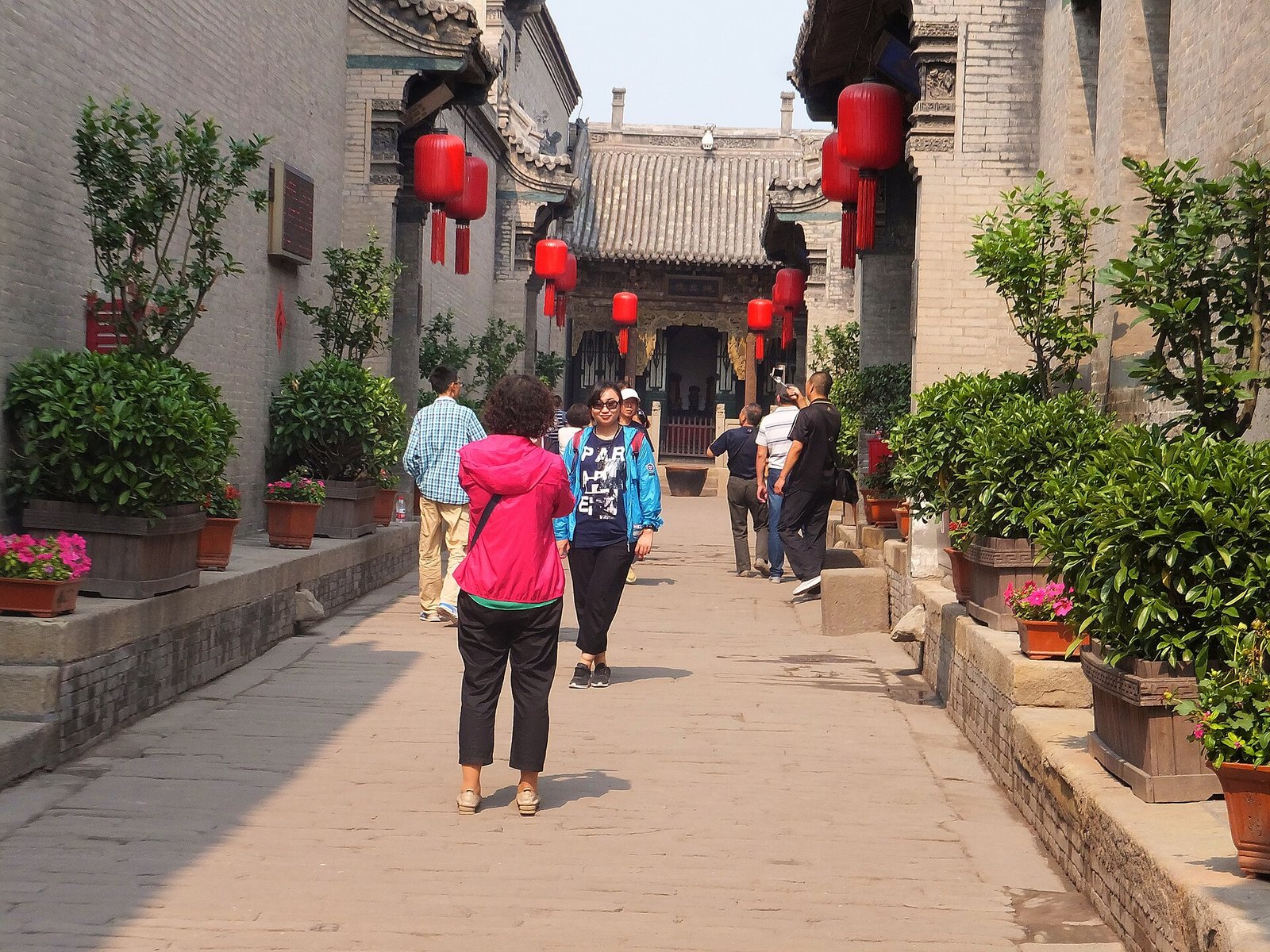 A lantern-hung courtyard lane inside the Qiao Family Compound, with visitors walking through