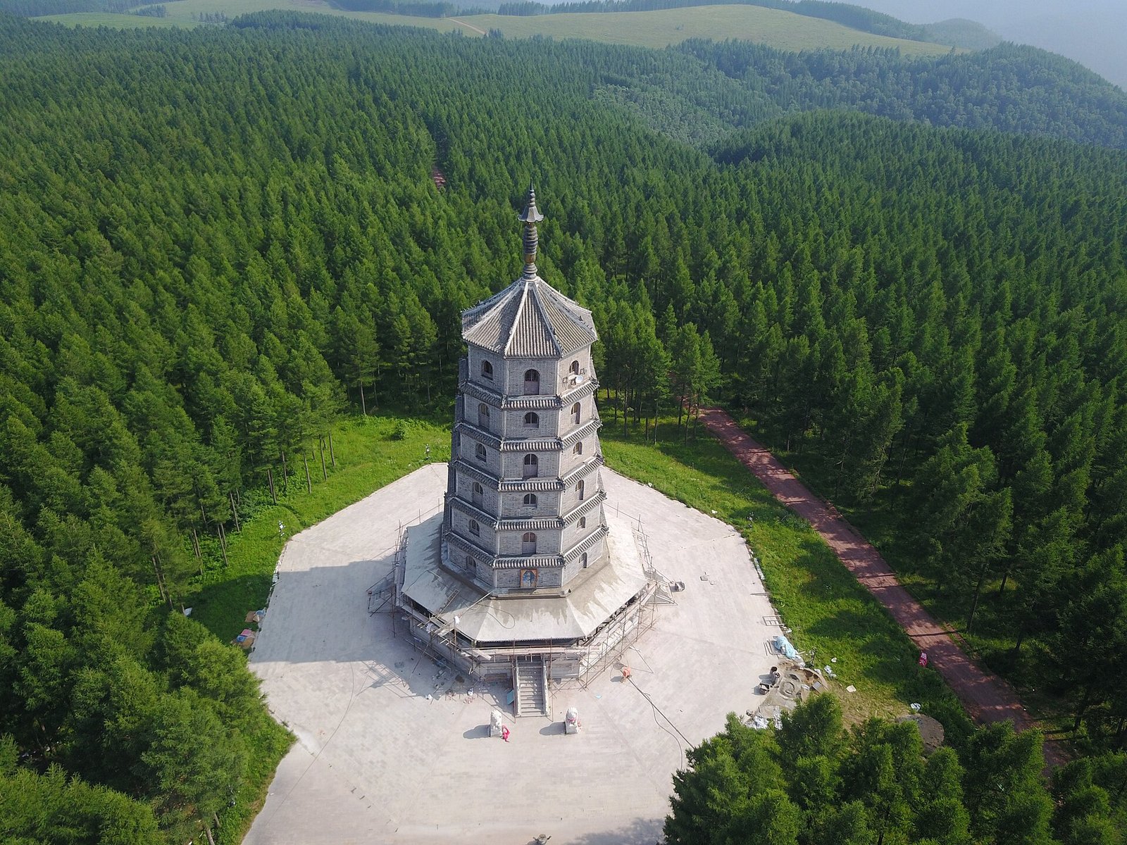 An aerial view of the Saihan Tower standing in dense conifer forest in Saikhanba, Hebei