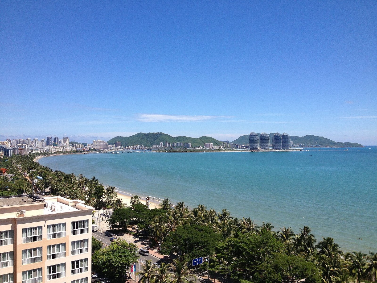 Sanya Bay with high-rise buildings along the shore and the curved towers of Phoenix Island in the distance