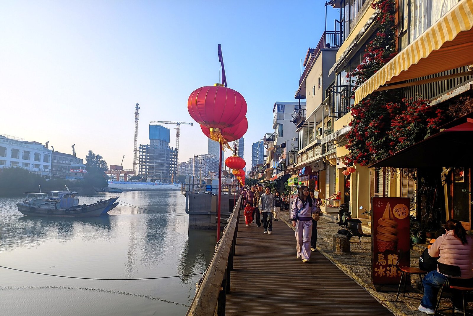 Crowds and shopfronts along the waterfront at Shapowei in Xiamen, with red lanterns and a stone quay