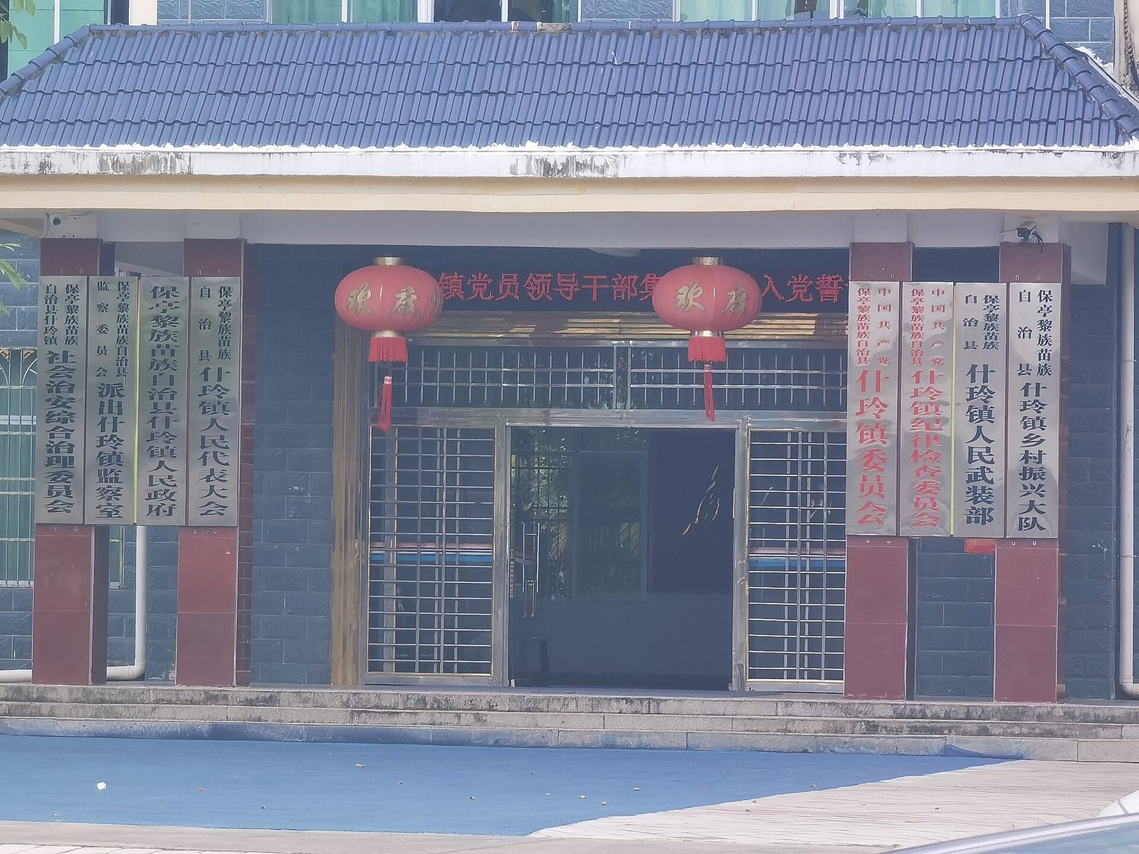 A two-storey town government building in Shiling, Baoting, with red lanterns and a blue signboard