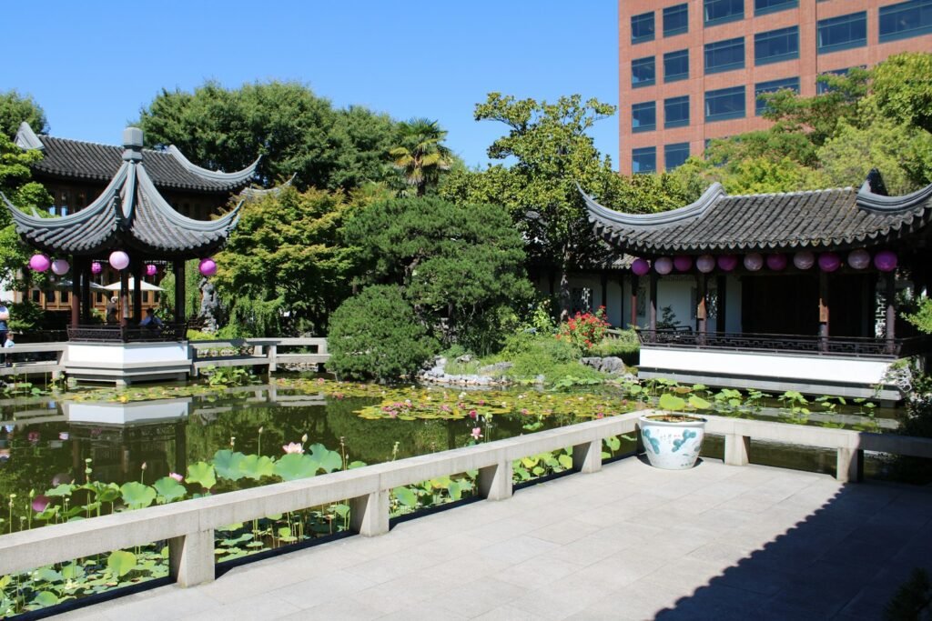 A classical Chinese garden with pavilions, a still pond and lush greenery