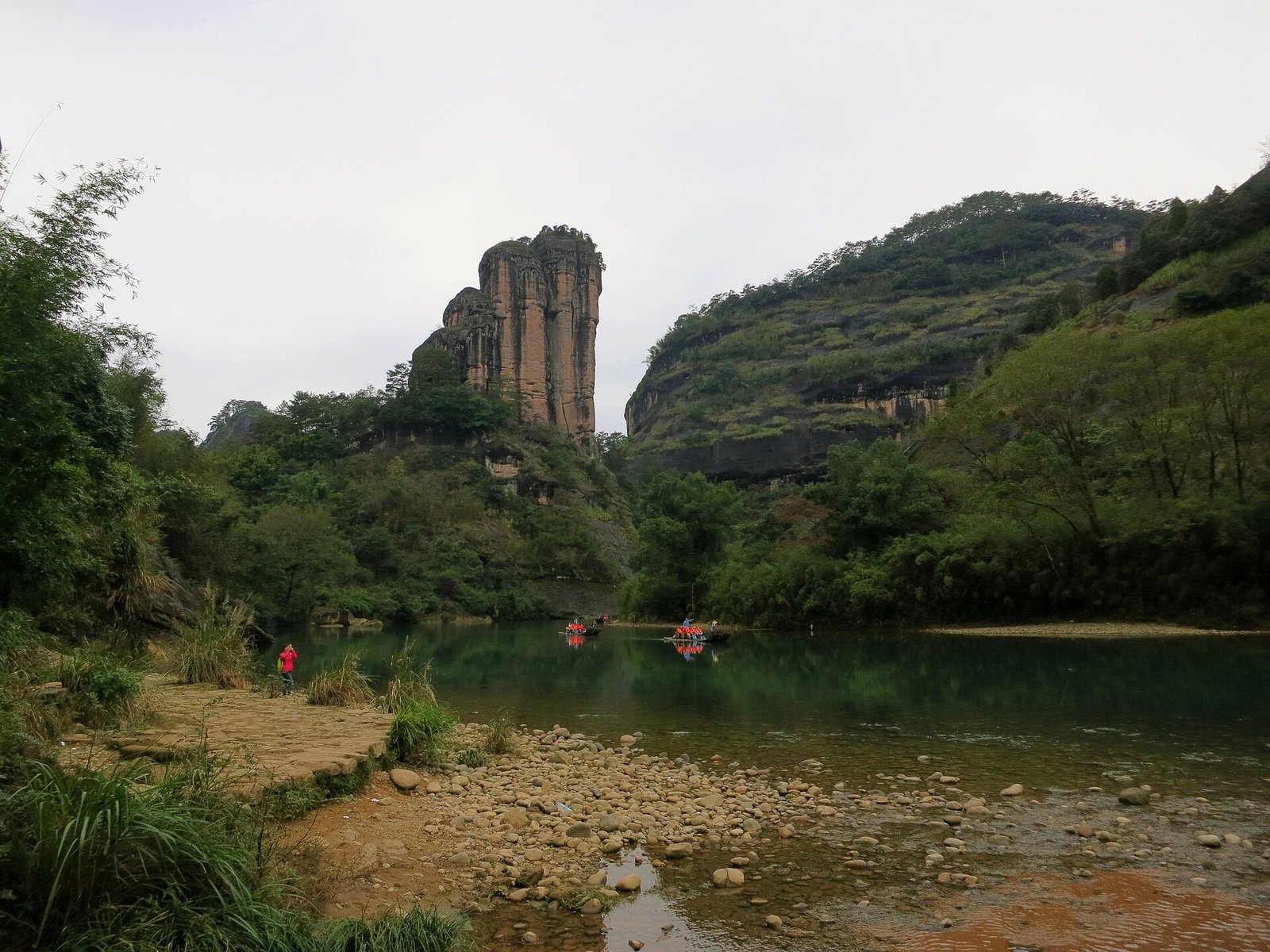 Jade Maiden Peak at Wuyishan, a single column of rock standing above the stream with rafts below