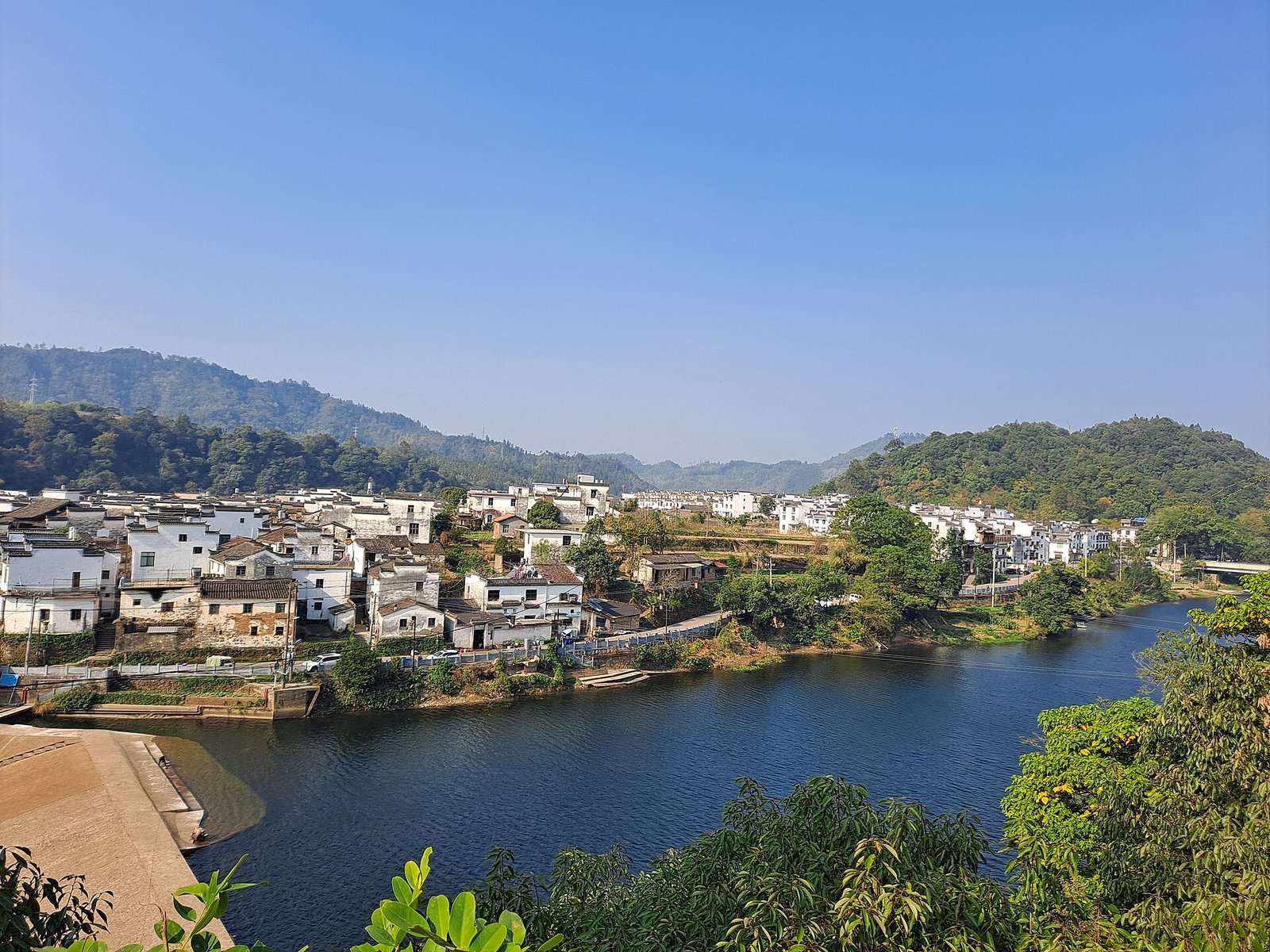 A river bend at Wangkou in Wuyuan, with a Huizhou village on the far bank under wooded hills