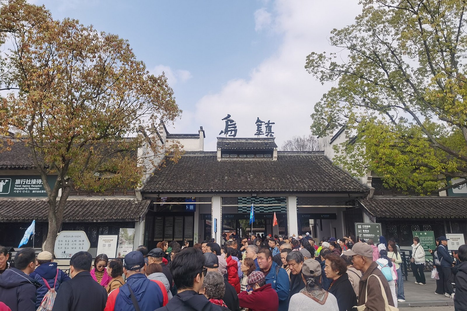 The ticket office and turnstiles at the entrance to Wuzhen Dongzha scenic area, with Chinese signage and a queue barrier
