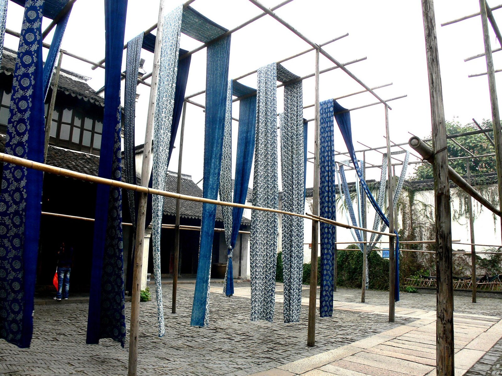 Long strips of indigo blue calico cloth hanging to dry in the yard of a dye workshop in Wuzhen