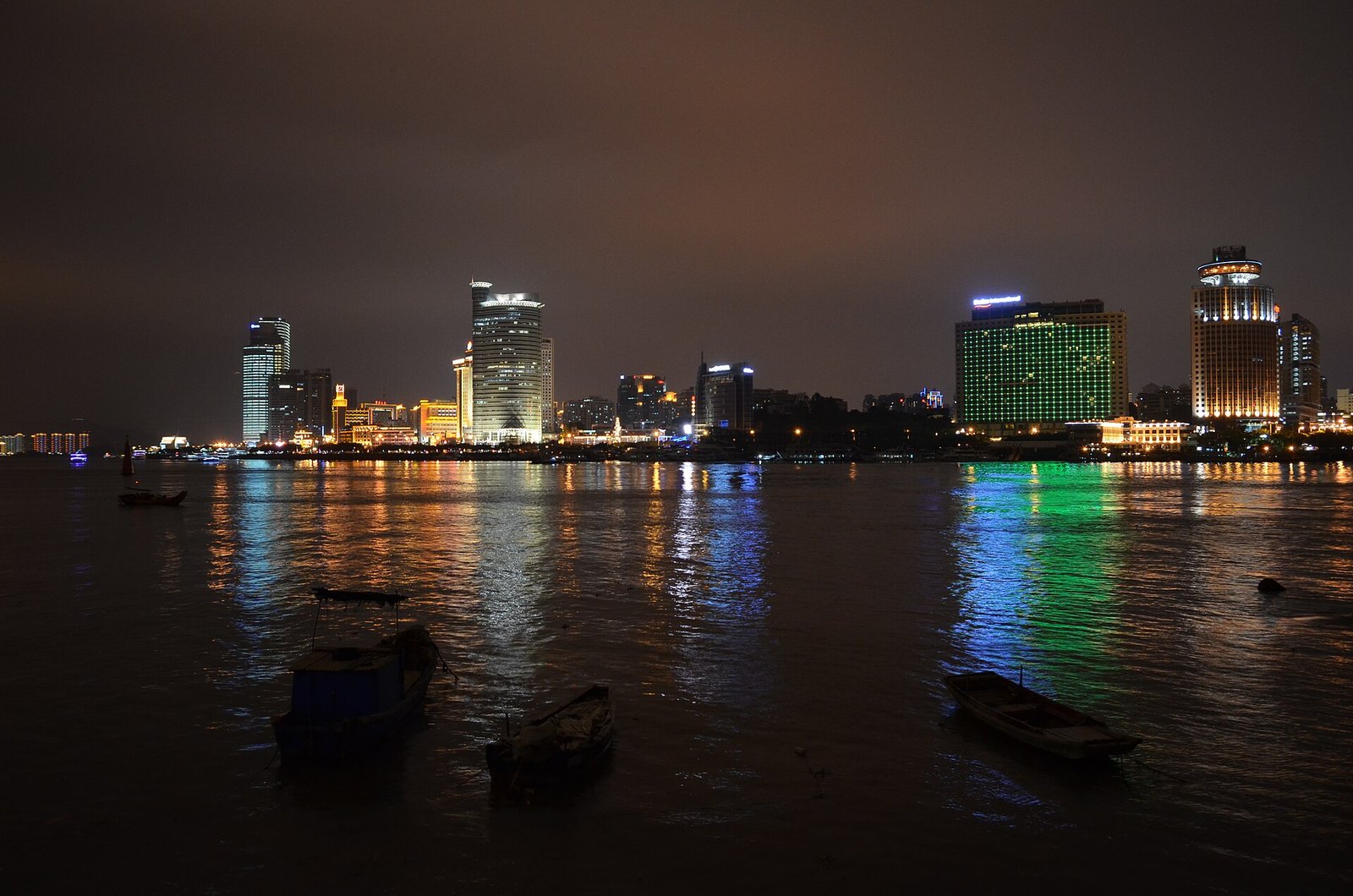 The Xiamen skyline at night seen across the water from Gulangyu, with lights reflected on the harbour