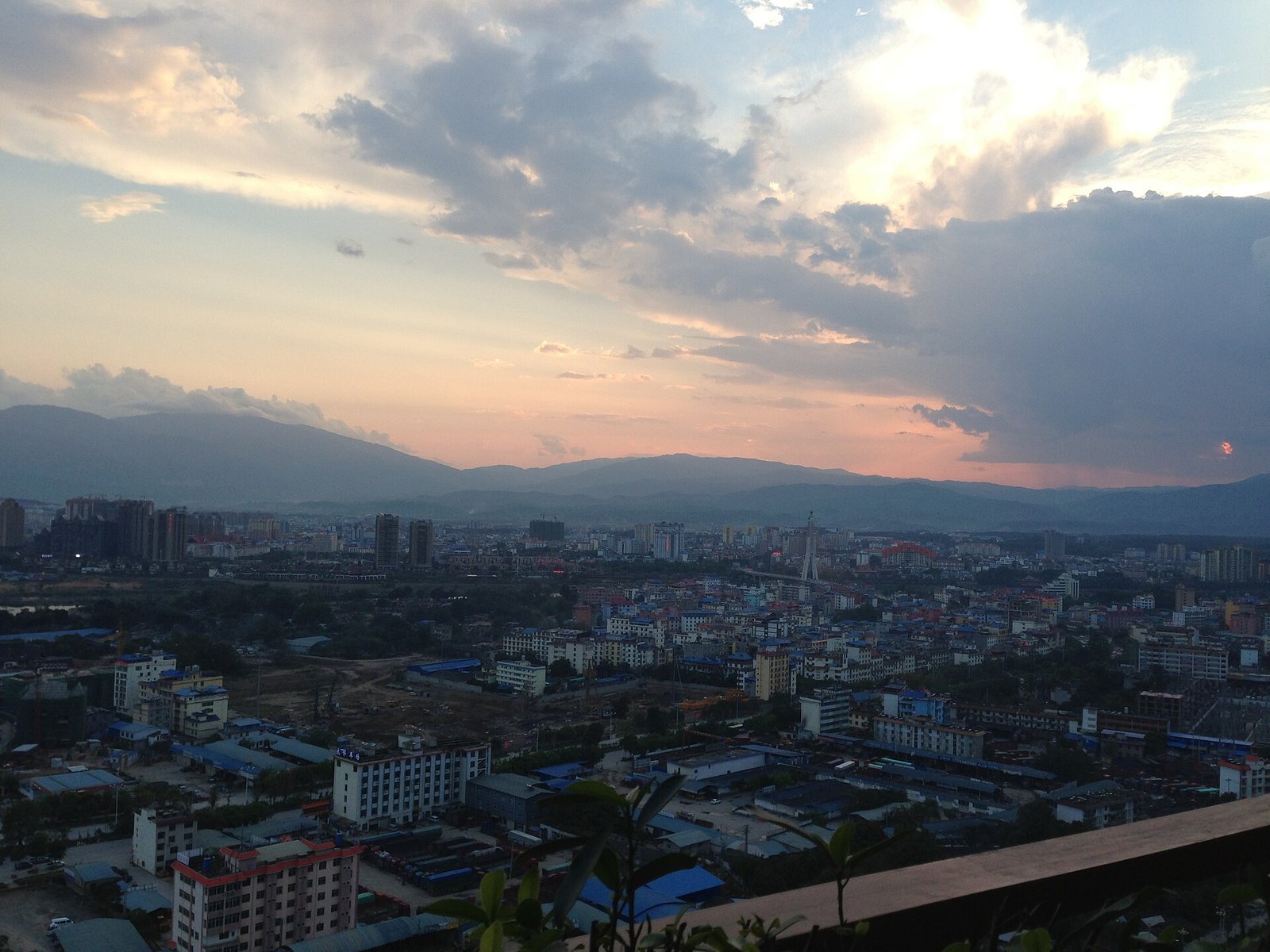 The city of Jinghong in Xishuangbanna, Yunnan, seen at dusk with low tropical hills behind it