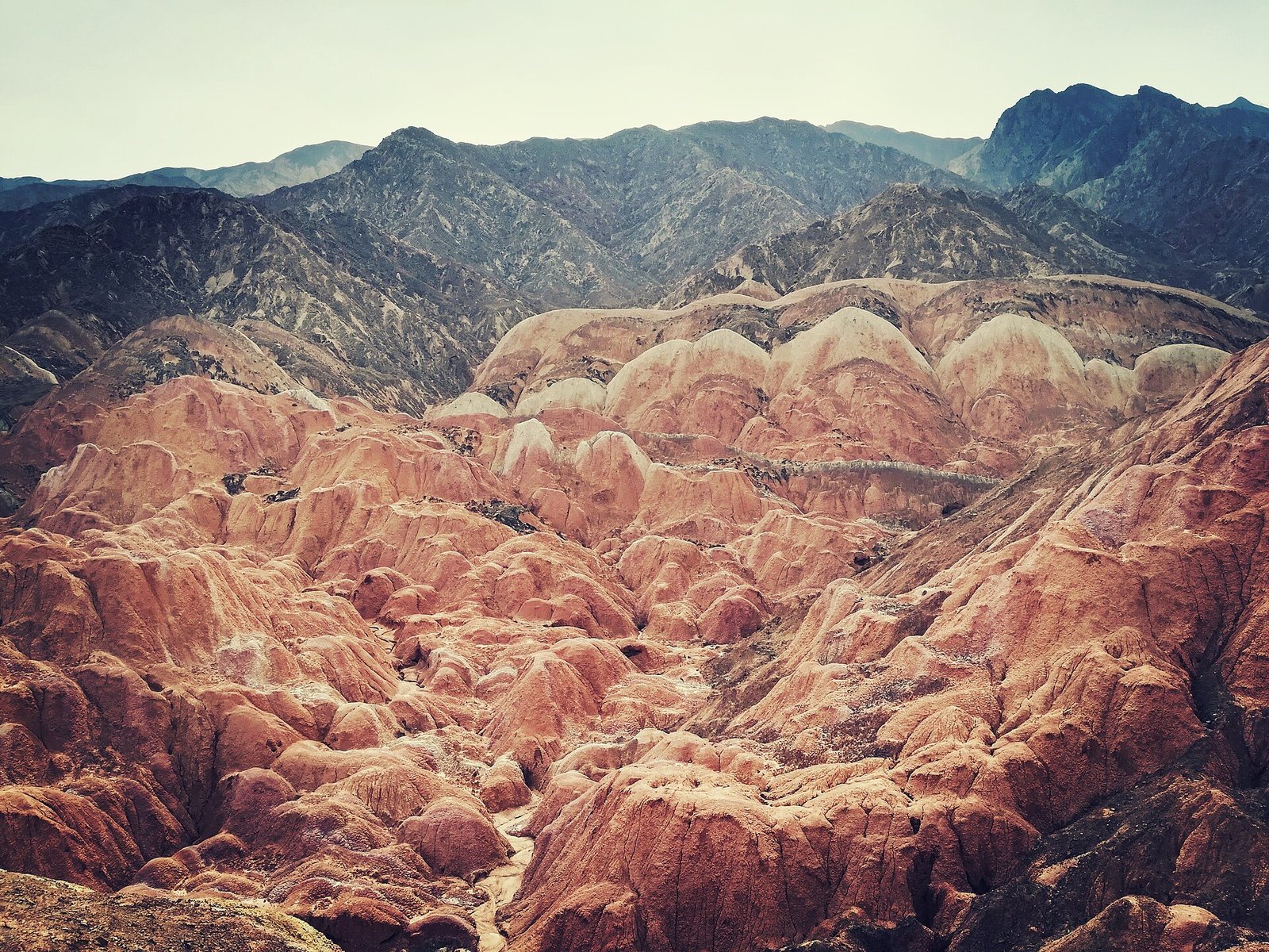 A vivid red and white banded ridge at Zhangye Danxia Geological Park, with a blue sky behind